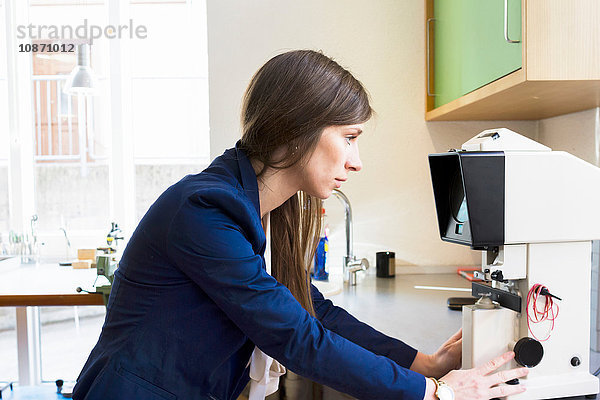 Seitenansicht eines Optikers mit Blick auf optische Geräte