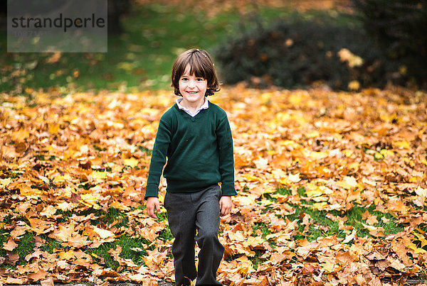 Junge im Park im Herbst  der lächelnd in die Kamera schaut