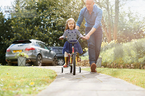 Vater bringt Tochter das Fahrradfahren auf der Straße bei