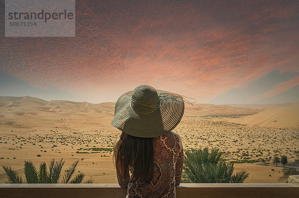 Frau auf dem Balkon  Blick auf die Wüste  bei Sonnenuntergang  Rückansicht  Abu Dhabi  Emirat Abu Dhabi  Vereinigte Arabische Emirate