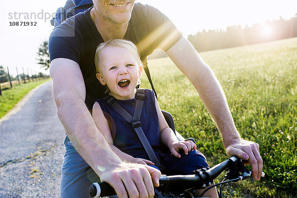 Vater und kleine Tochter fahren zusammen Fahrrad  Mittelteil