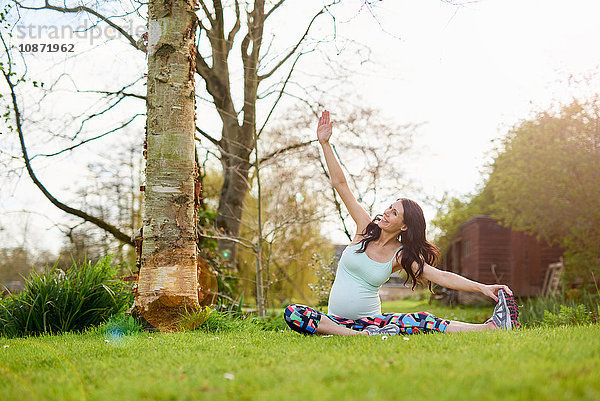 Schwangere Frau  die im Freien Sport treibt  Stretching