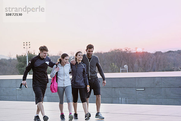 Vier Freunde tragen Sportkleidung  gehen zusammen spazieren  im Freien