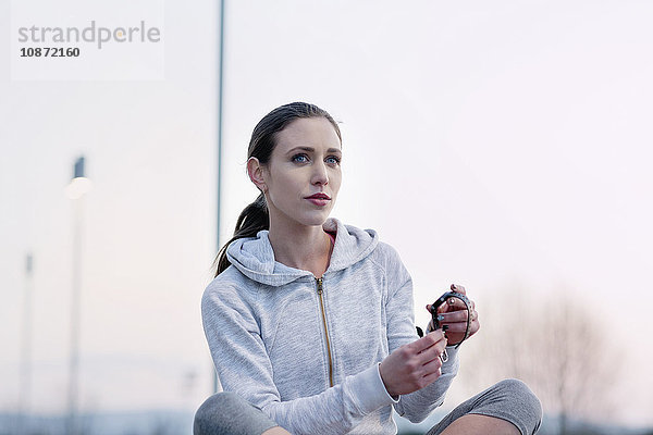 Junge Frau  Sportbekleidung tragend  Aktivitäts-Tracker anlegen