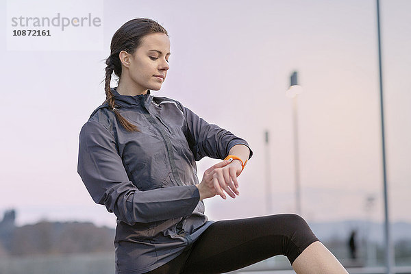 Junge Frau  in Sportkleidung  Blick auf Aktivitätsverfolger