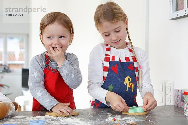 Mädchen an der Küchentheke  die Kekse zum Lächeln bringen