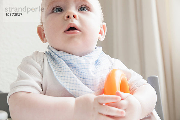 Kleiner Junge im Hochstuhl mit Beißring