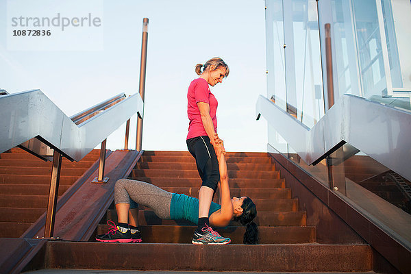 Zwei Frauen trainieren auf einer Treppe