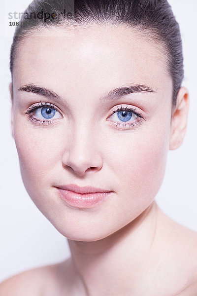 Kopf- und Schulteraufnahme einer schönen jungen Frau mit blauen Augen