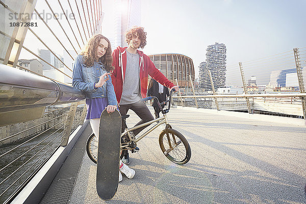 Mädchen und Mann mit BMX und Skateboard im Stadtgebiet