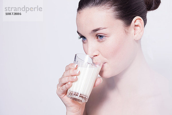 Porträt einer schönen jungen Frau  die ein Glas Milch trinkt
