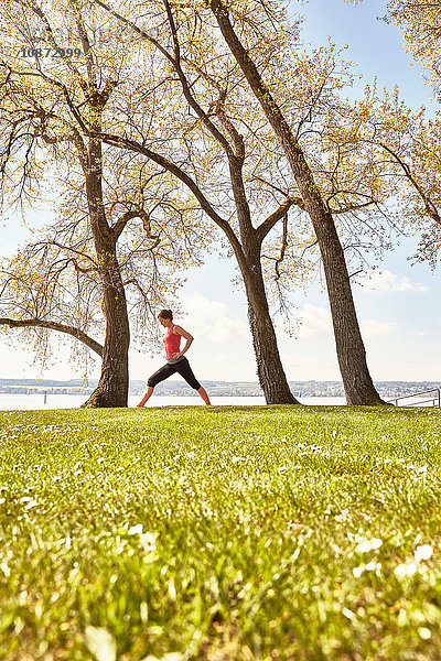 Seitenansicht einer Yoga praktizierenden Frau am See