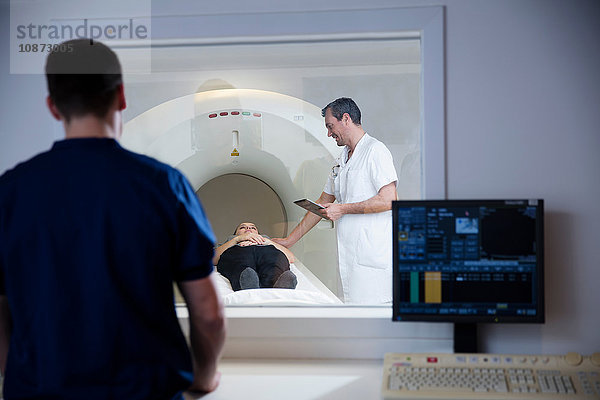 Ansicht des Kontrollraum-Fensters des Arztes  der den Patienten am CT-Scanner vorbereitet