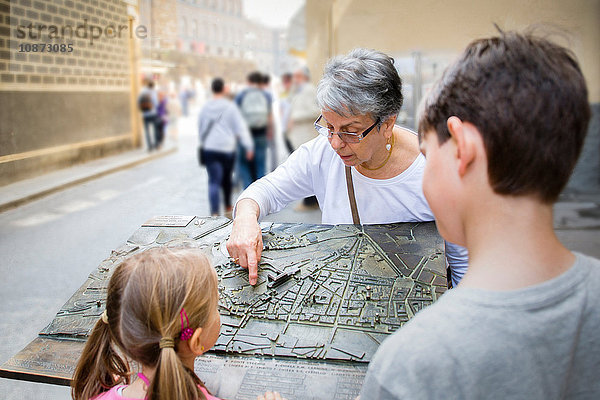 Ältere Frau und Enkelkinder zeigen auf Stadtplan  Florenz  Italien