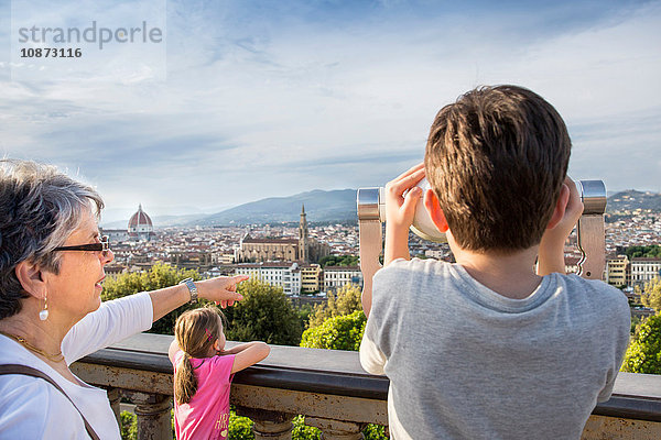 Ältere Frau und Enkel betrachten das Stadtbild mit einem Münzfernglas  Florenz  Italien