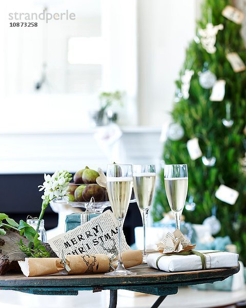 Champagner-Tisch mit Weihnachtskräckern und Geschenken
