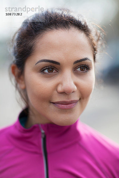 Porträt einer jungen Frau in rosa Trainingsjacke