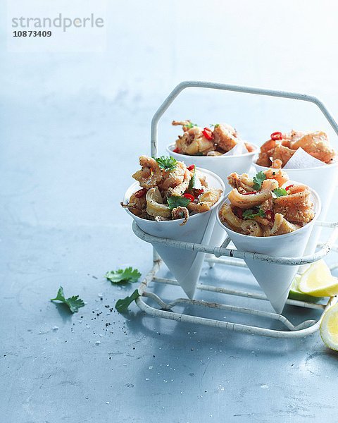 Salz- und Pfeffer-Chili-Tintenfisch  garniert mit Zitrone und Koriander in Papiertüte