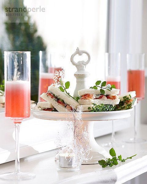 Champagnerflöten mit rosa Champagner und Flusskrebs-Sandwiches am Kuchenstand