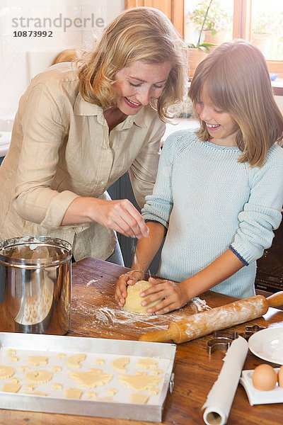 Mutter und Tochter backen Kekse