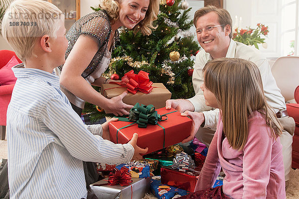 Junge und Mädchen erhalten Weihnachtsgeschenke