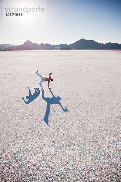 Mann mit zwei Schatten beim Capoeira-Spiel auf Bonneville Salt Flats  Utah  USA