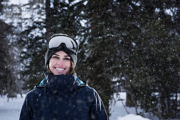 Porträt einer jungen Frau mit Skibrille im Schnee  Brighton Ski Resort ausserhalb von Salt Lake City  Utah  USA