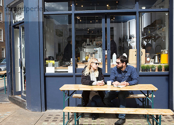 Ehepaar sitzt am Tisch im Straßencafé