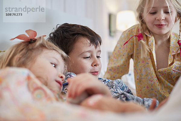 Kinder im Schlafanzug im Bett