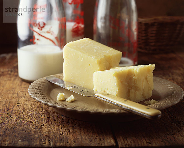 Lebensmittel  Milchprodukte  reifer Cheddar-Käse  Milchflaschen  traditionelles Bauernhaus