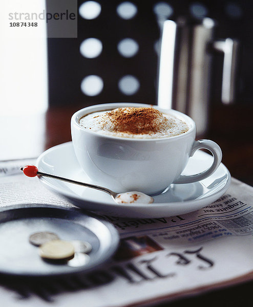 Cappuccino auf Zeitung im Kaffeehaus