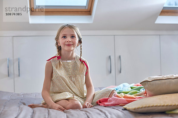 Mädchen sitzt auf dem Bett im Hochbett