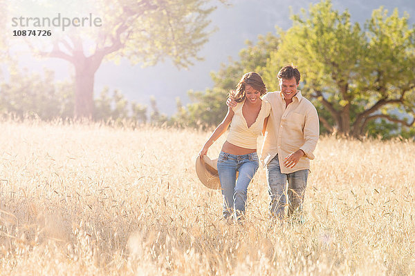 Romantisches Paar beim Spaziergang auf einem Feld aus Langgras  Mallorca  Spanien
