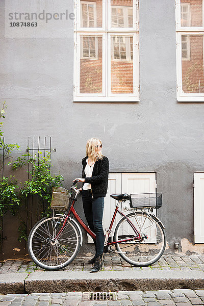 Frau mit Fahrrad auf dem Bürgersteig  Kopenhagen  Dänemark