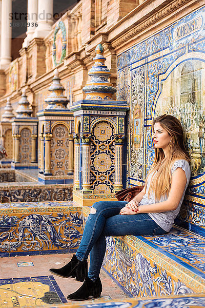 Junge Frau sitzt entspannt auf der Plaza de Espana  Sevilla  Andalusien  Spanien