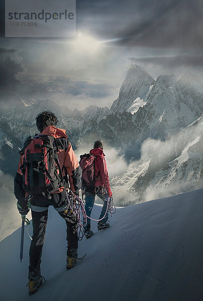 Zwei Bergsteiger auf einem verschneiten Hang mit Blick auf die Grand Jorasses  im Mont-Blanc-Massiv  Chamonix  Frankreich