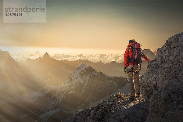 Bergsteiger beim Beobachten einer Bergkette bei Sonnenuntergang  Alpen  Kanton Wallis  Schweiz