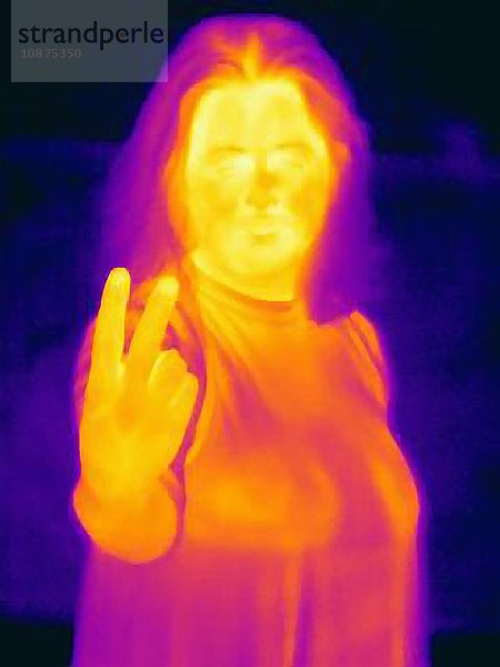 Wärmebild einer Frau  die mit obszöner Fingergeste die Hand hochhält