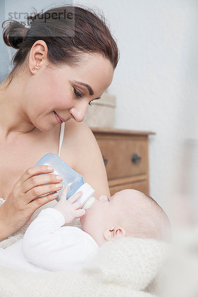 Mutter füttert Baby mit der Flasche