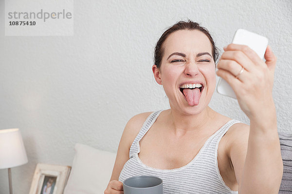 Frau zieht Gesicht  Selbstporträt mit Smartphone