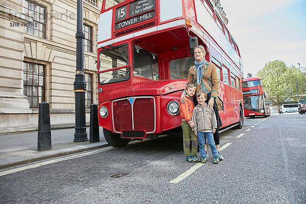 Mutter und Söhne vor rotem Doppeldeckerbus