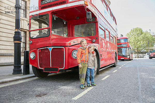 Jungen vor rotem Doppeldeckerbus