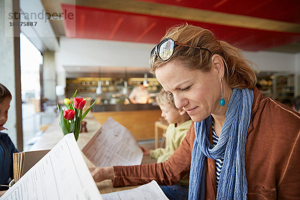 Mutter und Sohn im Café beim Blick auf die Speisekarte