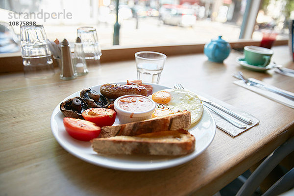 Vollständiges englisches Frühstück am Schalter am Fensterplatz im Cafe