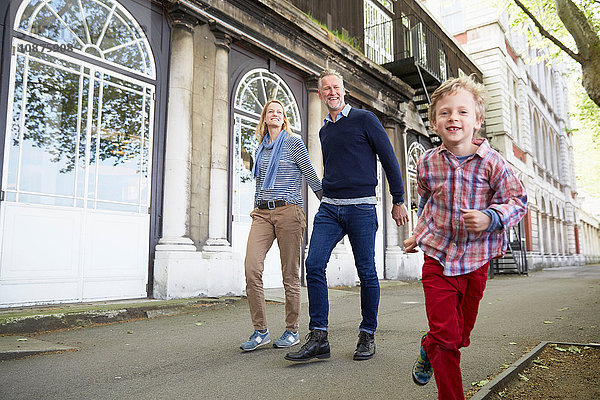 Familie geht auf der Straße und hält sich an den Händen