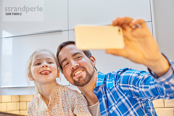 Vater und Tochter beim Selbstverzehr in der Küche