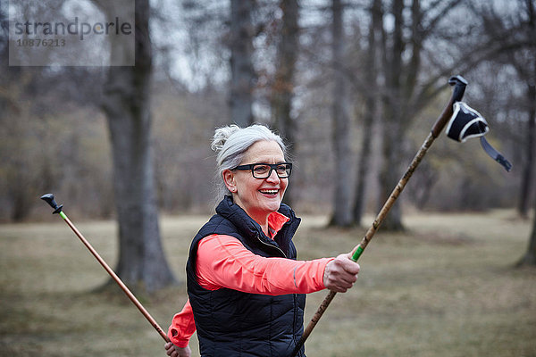 Ausgereiftes Frauentraining im Park  Training mit Nordic-Walking-Stöcken