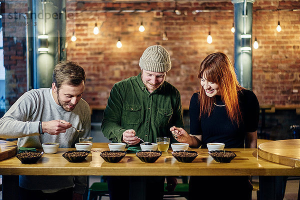 Team des Coffeeshops probiert Schalen mit Kaffee und Kaffeebohnen