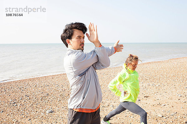 Männer- und Frauentraining  Stretching am Strand von Brighton