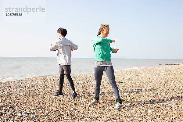 Mann und Frau trainieren  twisten am Strand von Brighton